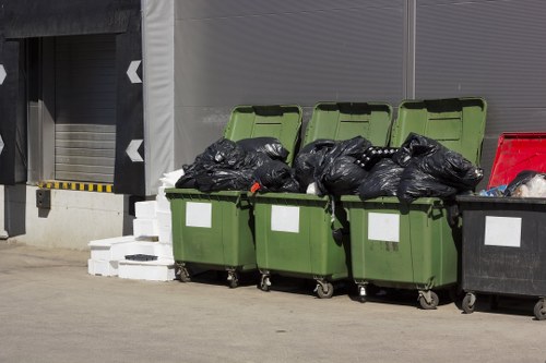 Workers loading waste into a skip